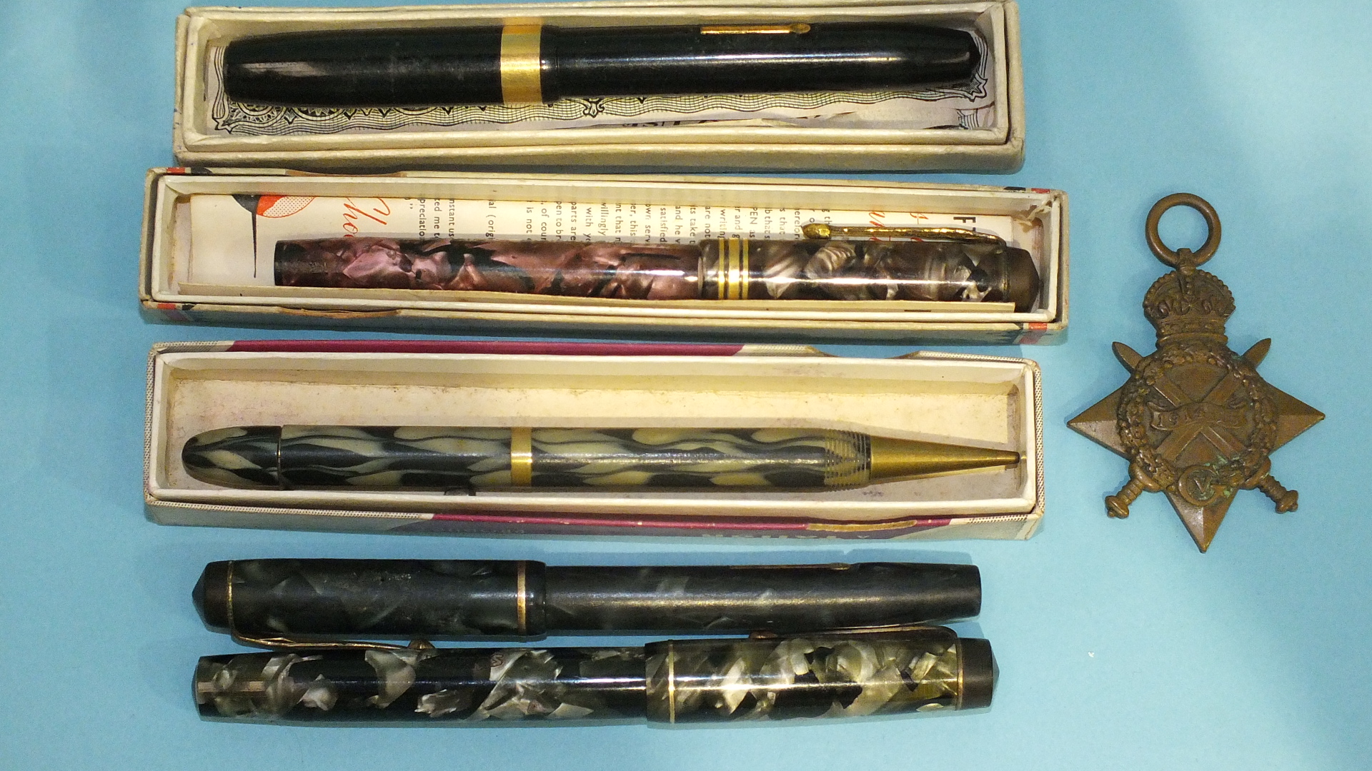 A Conway Stewart fountain pen in case, three others, a pencil and a 1914-1915 Star, (4).