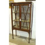 An Edwardian mahogany display cabinet, the rectangular top above a pair of glazed doors and glazed
