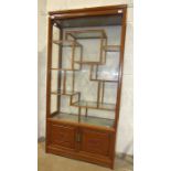 A 20th century Chinese-style hardwood and glazed display cabinet fitted with hinged side doors,