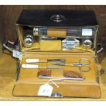 A chromium-plated and glass travelling vanity set in fitted case, a small plated two-handled tray