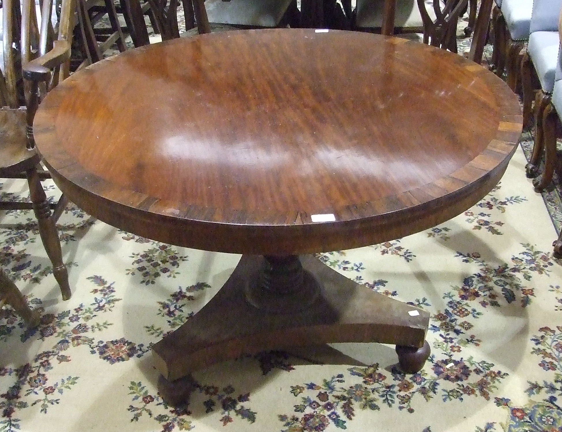 An early-19th century circular mahogany and rosewood-banded breakfast table raised on turned