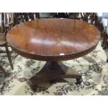 An early-19th century circular mahogany and rosewood-banded breakfast table raised on turned