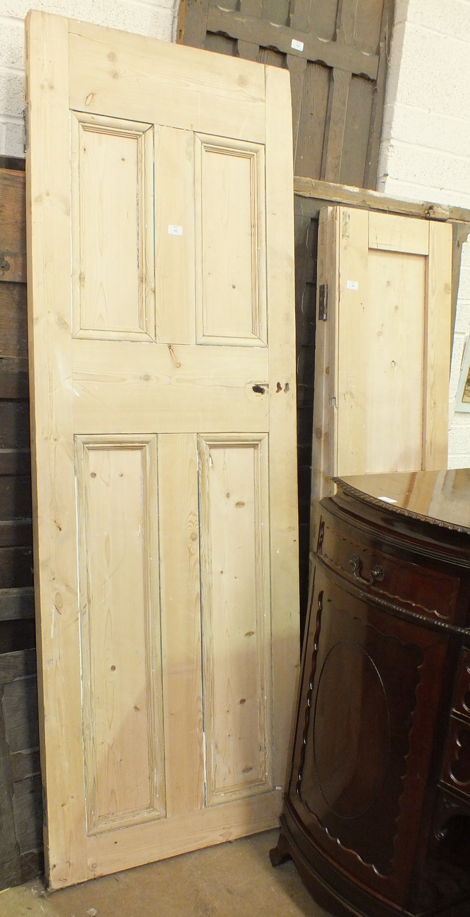 A stripped pine door, 207 x 72.5cm and a pair of smaller doors, each 171.5 x 43.5cm, (2).