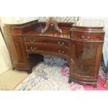 An early-20th century mahogany pedestal sideboard of concave outline, having a pair of cupboard