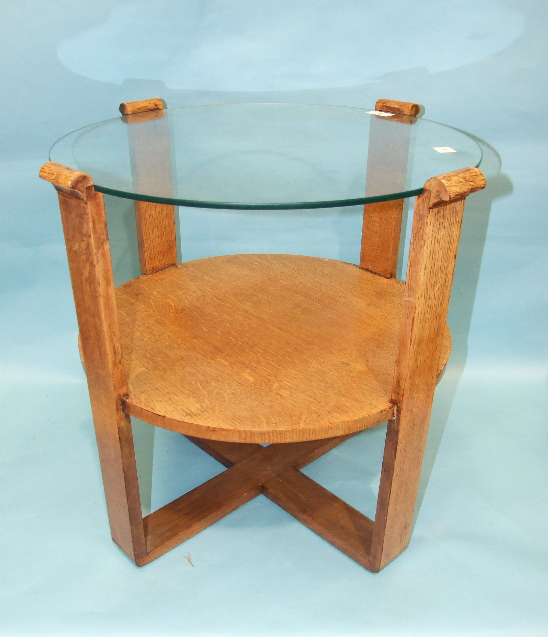 A 1950's/1960's oak circular occasional table with plate glass top, the supports joined by an