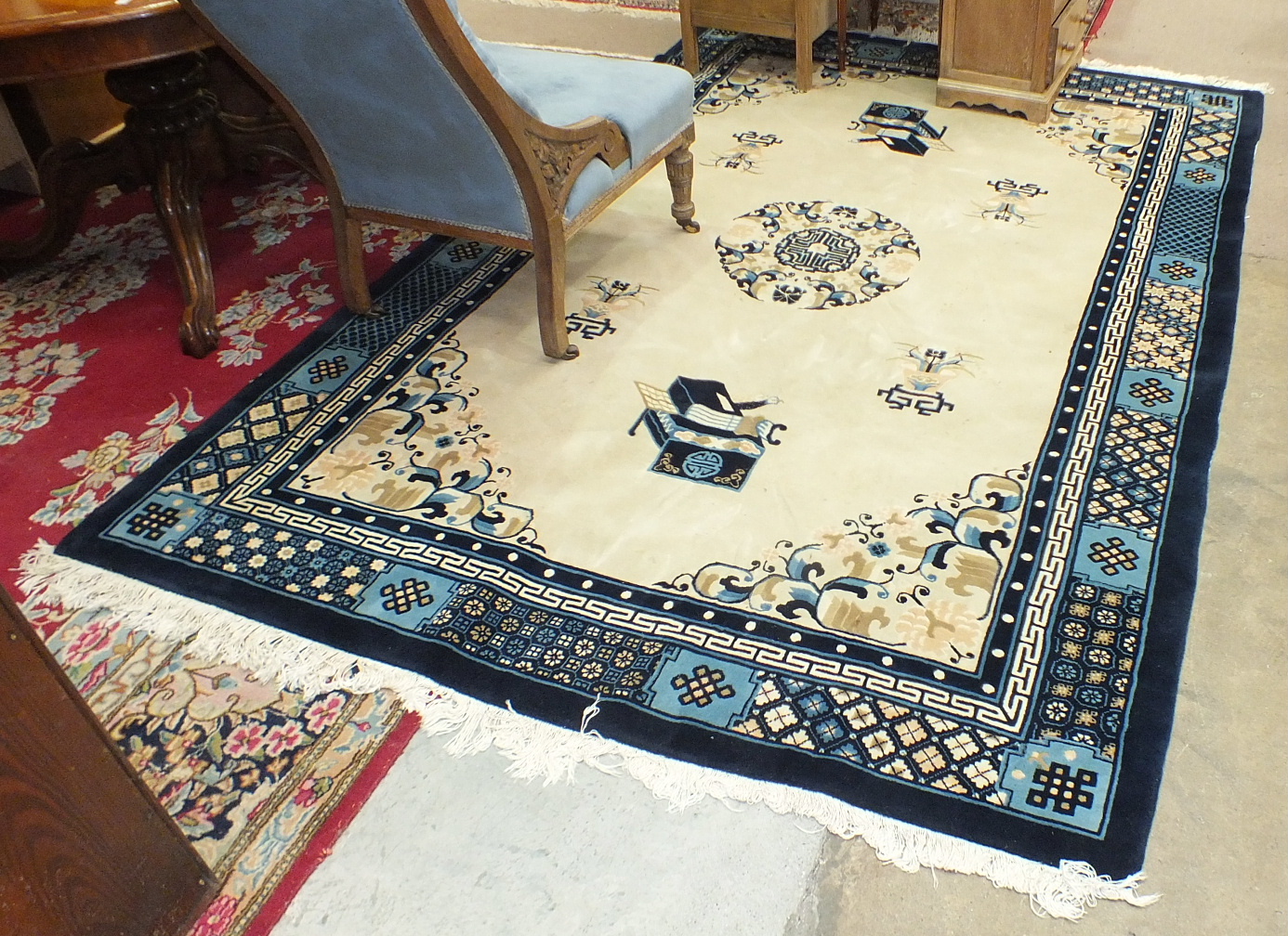 A large modern Chinese rug with deep blue borders on a camel-coloured ground, 279 x 184 and a