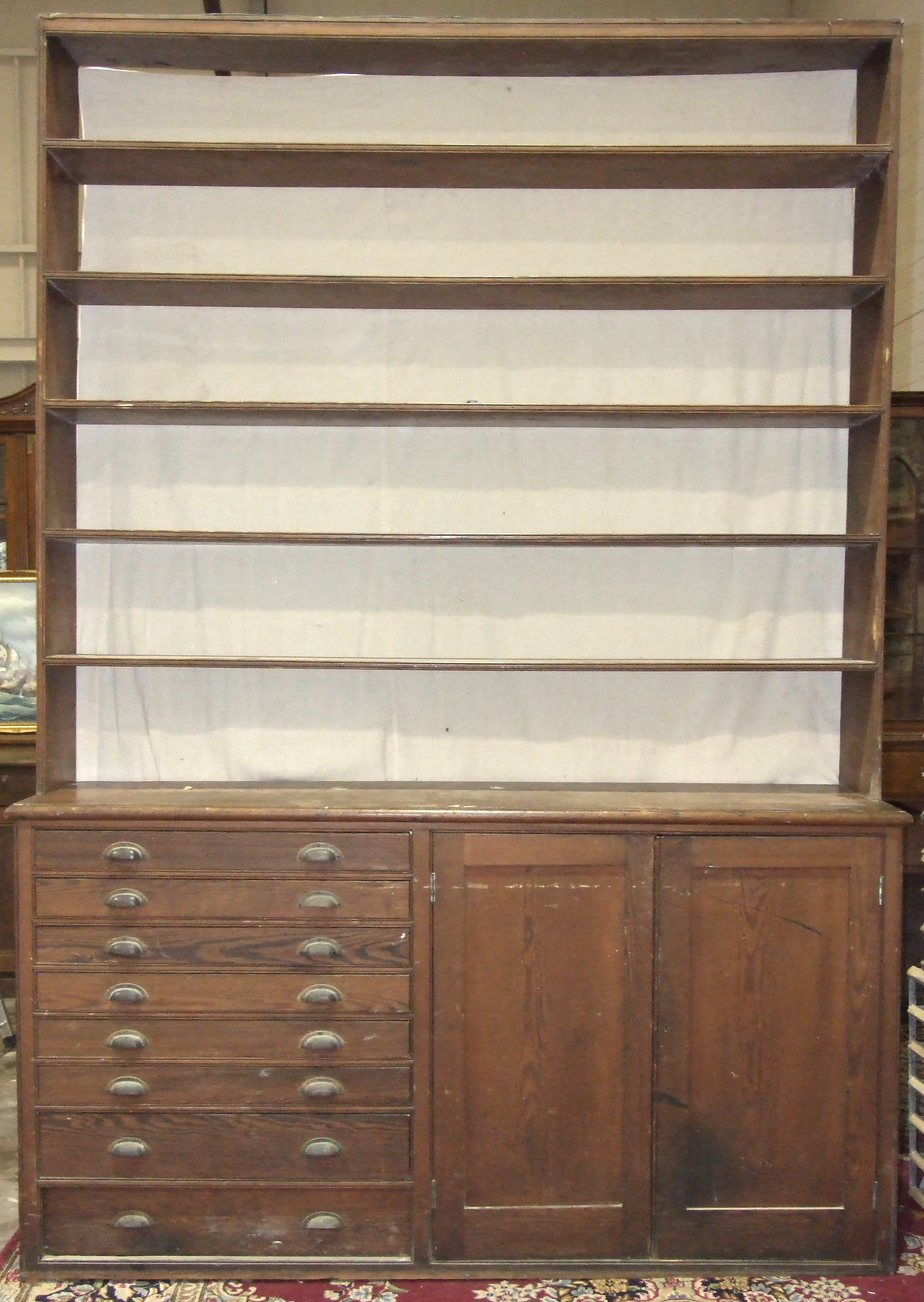 A large pitch pine dresser, the five-tier open shelves above the base fitted with eight plan drawers