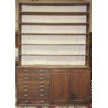 A large pitch pine dresser, the five-tier open shelves above the base fitted with eight plan drawers
