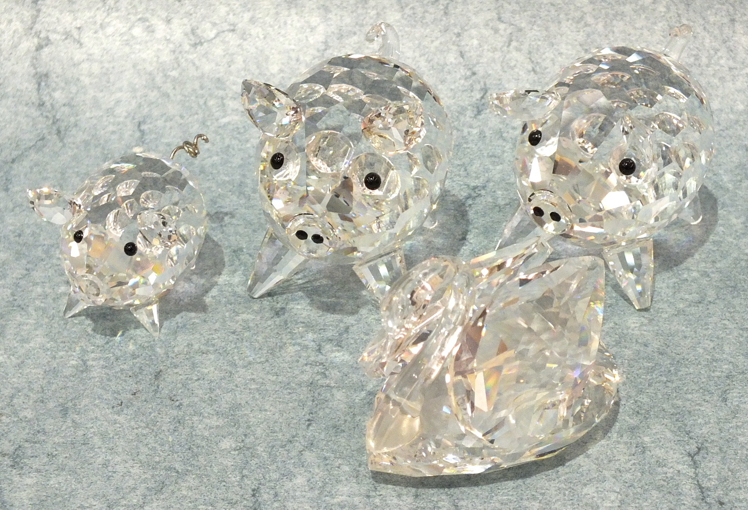 Two Swarovski large crystal pigs, 5cm high, a smaller pig and a swan, all boxed, (4).