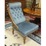 A Late-Victorian oak-framed upholstered button-back salon chair on reeded front legs.