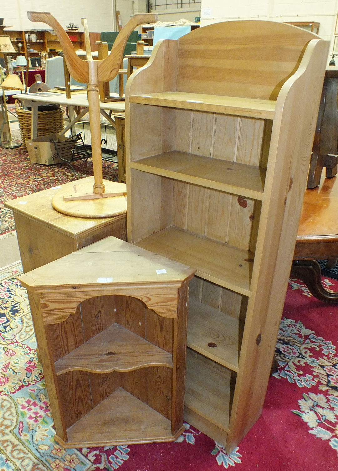 A stained pine bedside cupboard, a set of five-tier narrow pine bookshelves, 45.5cm wide, 131cm