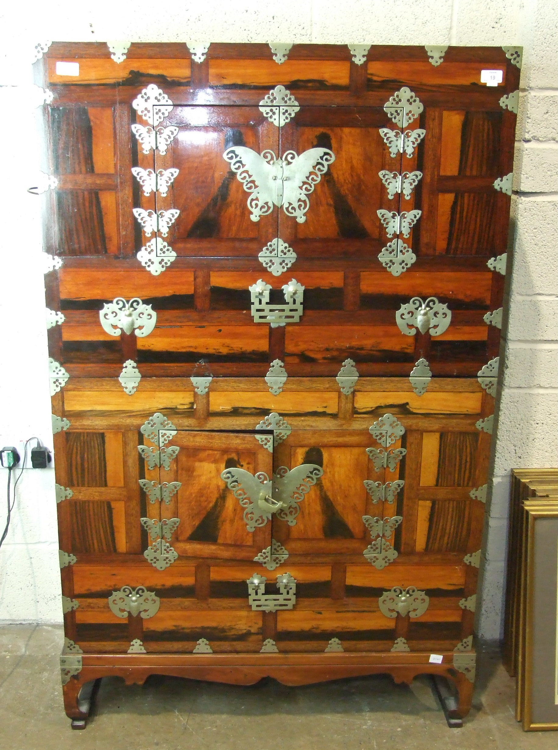 An Oriental 20th century rosewood-veneered two-section cupboard, each section fitted with a pair