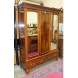 An Edwardian mahogany wardrobe, the cornice above a pair of mirrored doors, on a two-drawer base,