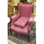 An upholstered armchair with stained wood frame, in the Victorian taste.