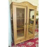 A Continental stripped pine cupboard with glazed sides and two glazed doors, with shelved interior