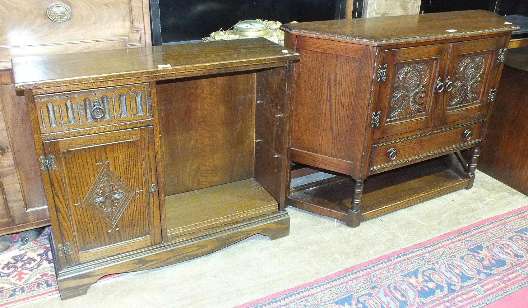 A modern low oak hall cupboard, the shaped top above a pair of doors and single drawer, on turned