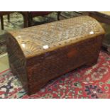 A teak domed-top chest carved overall with stylised flowers and sun bursts on the corners, 80cm