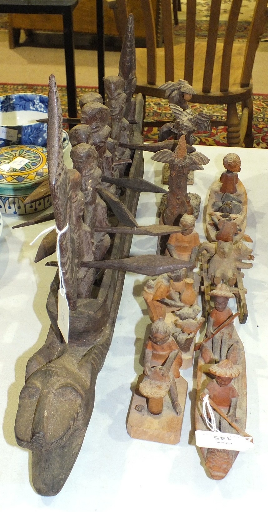 A carved wooden dragon boat group with seven rowing figures holding paddles, 70cm long and other