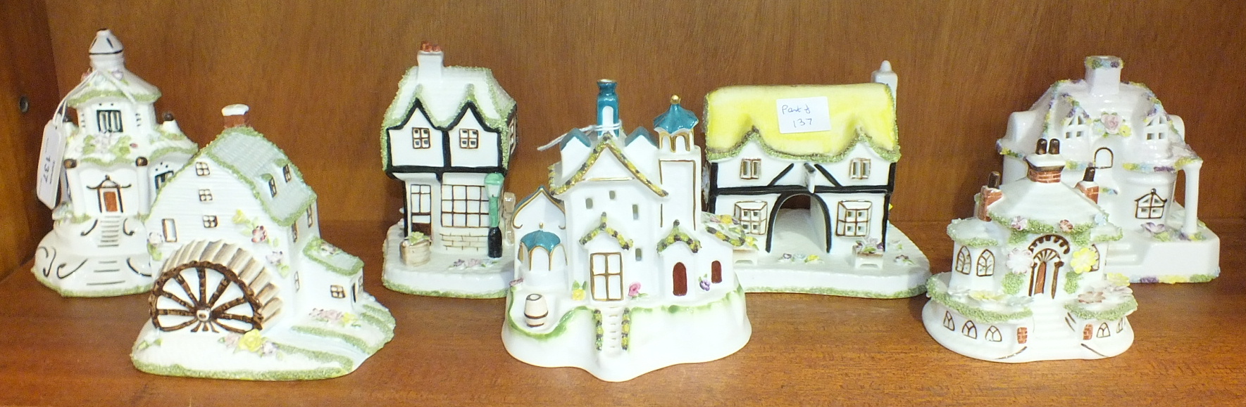 A collection of seven Coalport bone china cottage models, including: 'The Country Cottage', 'Keepers