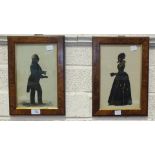 A pair of Georgian-style gilt and black silhouette pictures of a gentleman and lady, both holding