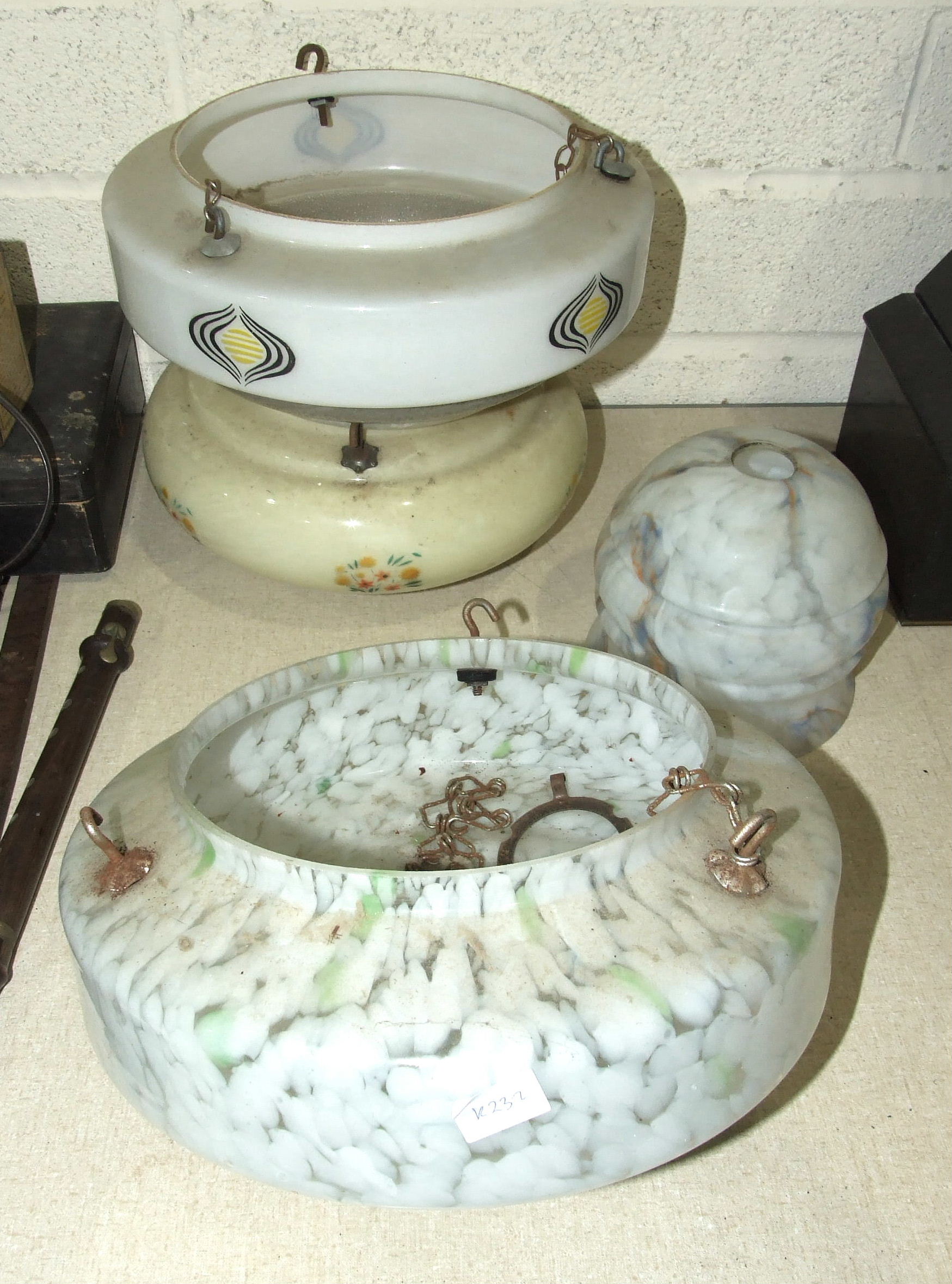 Four mid-20th century glass light shades and a glass carboy.