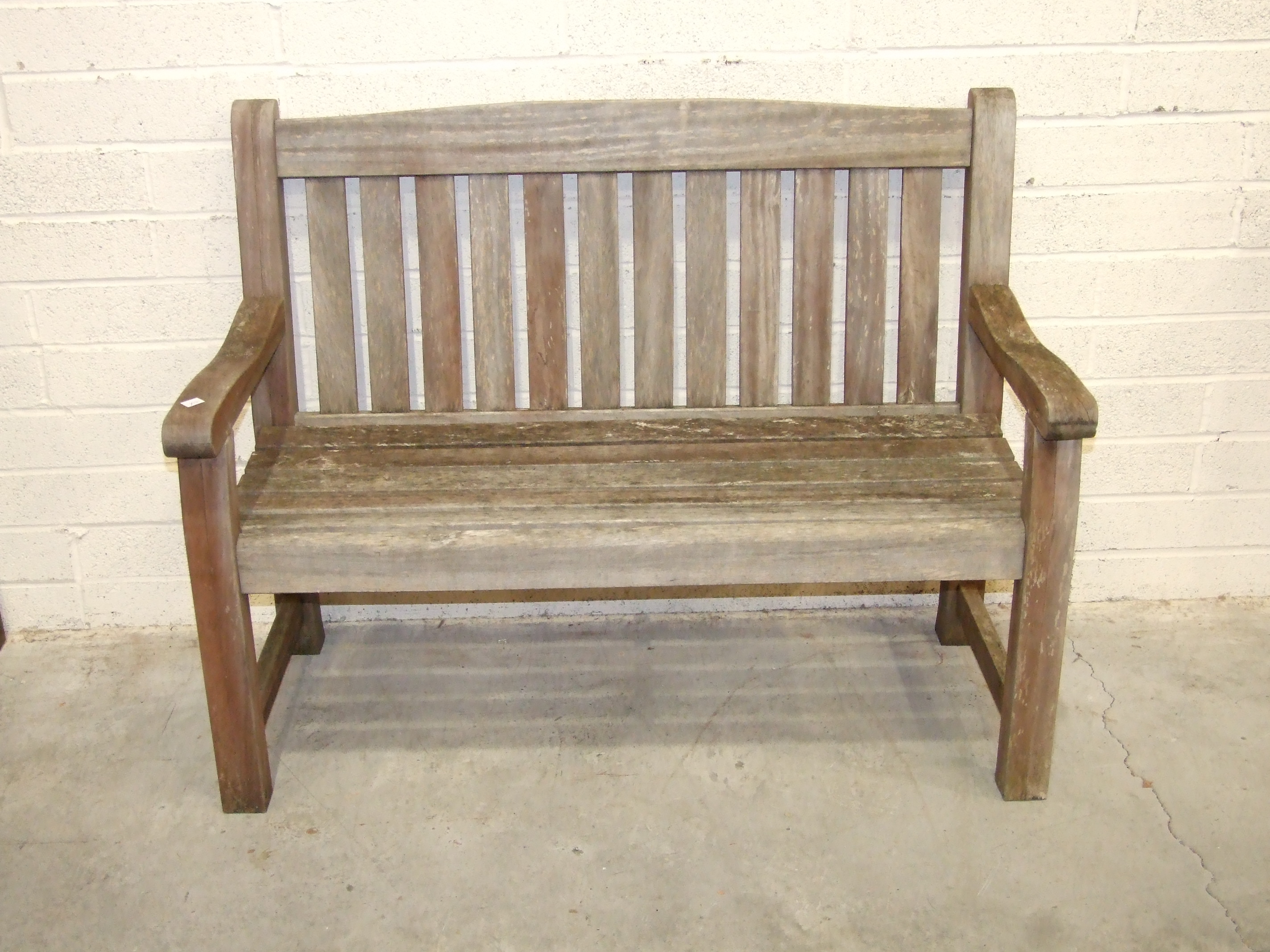 A teak garden bench, 123cm wide.