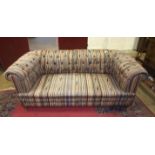 An Edwardian upholstered two-seater Chesterfield settee on short turned legs, 180cm wide.