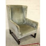 A deep-seated upholstered 'Gainsborough'-style armchair on short square legs joined by stretchers,
