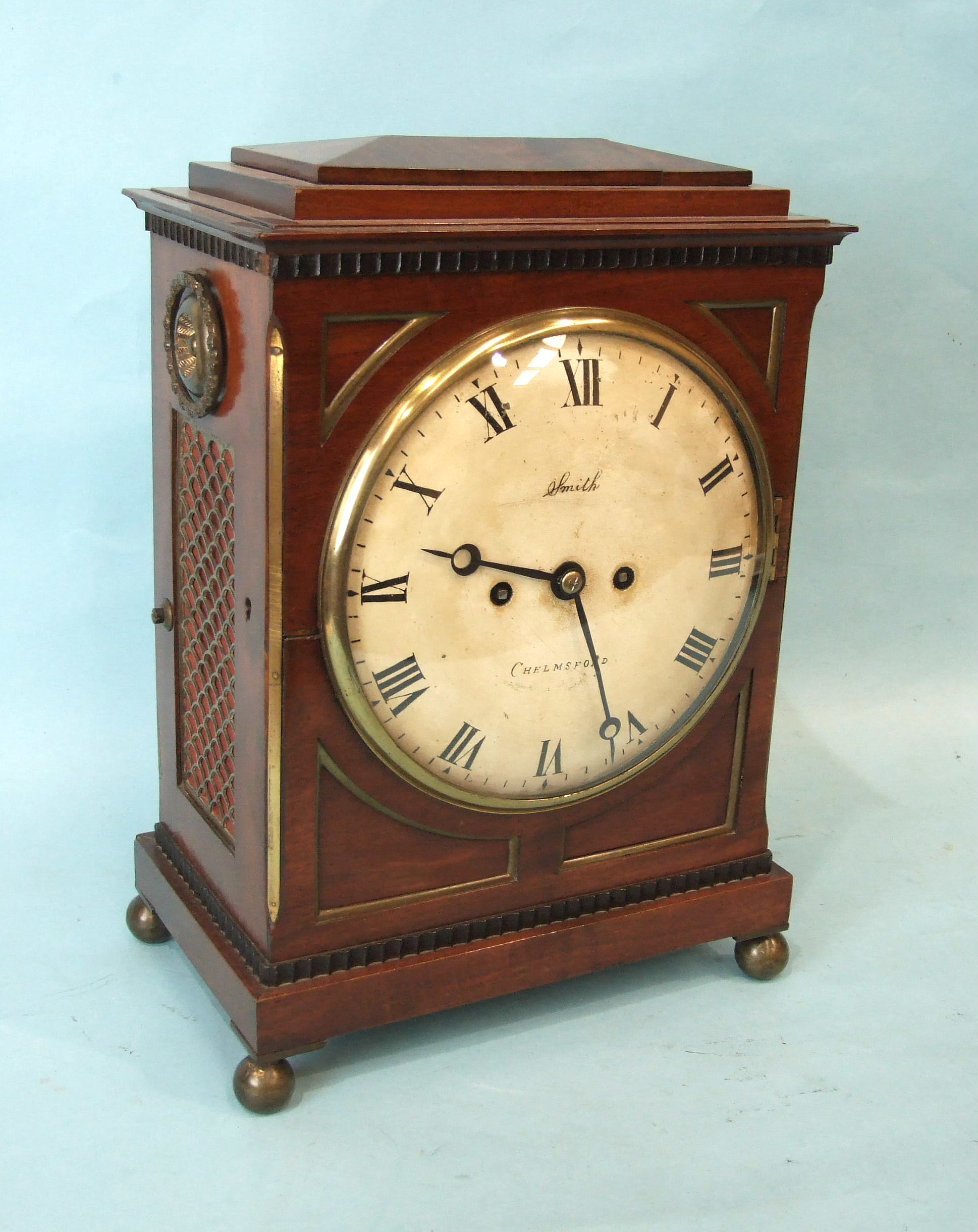 A Regency mahogany bracket clock, the case with brass detail, pierced side panels, carrying