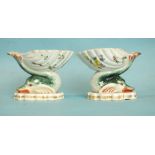 A pair of 19th century Berlin salts, each in the form of a shell supported by a dolphin, the bowls