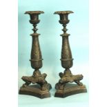 A pair of Regency-style bronze candlesticks, each leafy column supported by three legs with paw