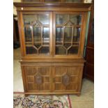 An Edwardian walnut bookcase, having a pair of astragal-glazed doors, above two panelled doors, by