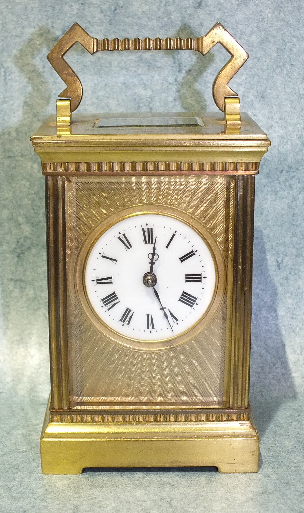 A 19th century French carriage clock, the engine-turned gilt metal face with circular enamel dial