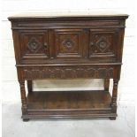 A reproduction oak court cupboard in the Tudor style, having a central Tudor rose carved panel,