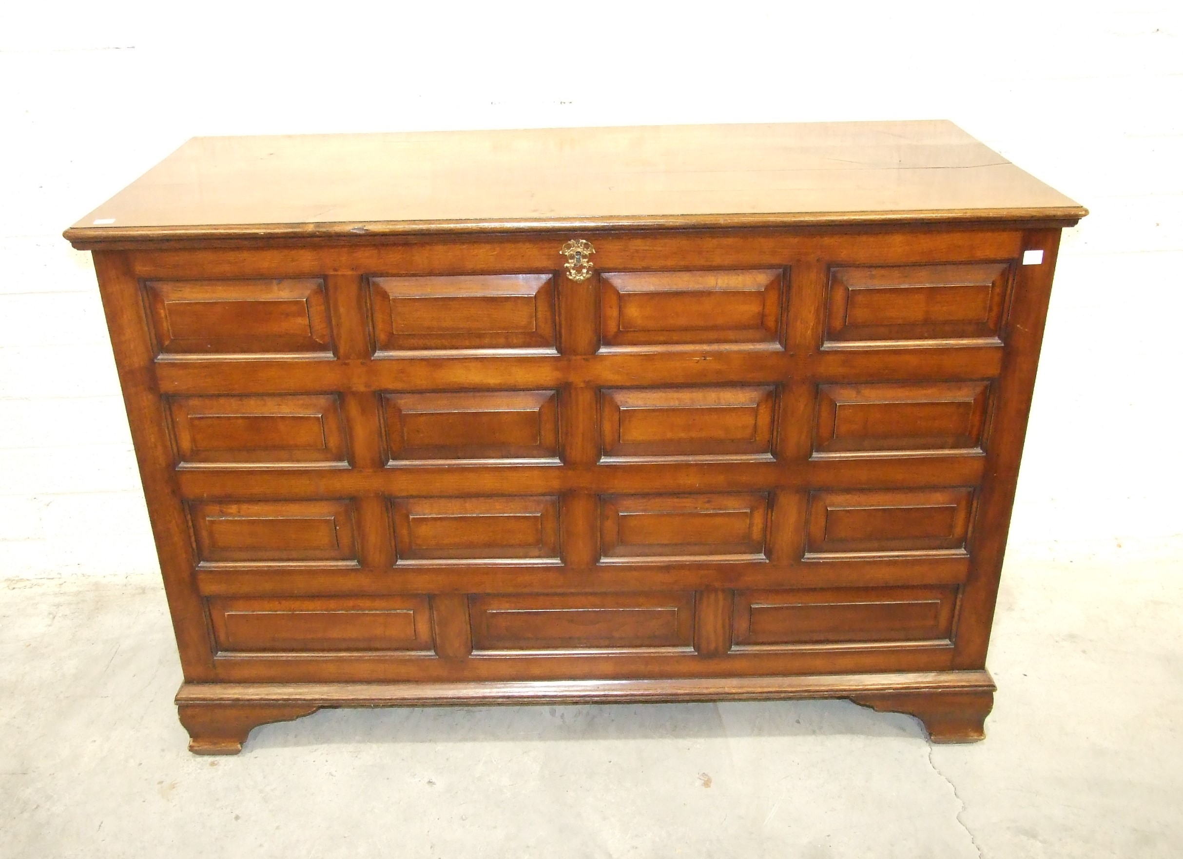 A large oak hall chest constructed of fielded panels, raised on shaped bracket feet, 143cm wide,