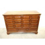 A large oak hall chest constructed of fielded panels, raised on shaped bracket feet, 143cm wide,