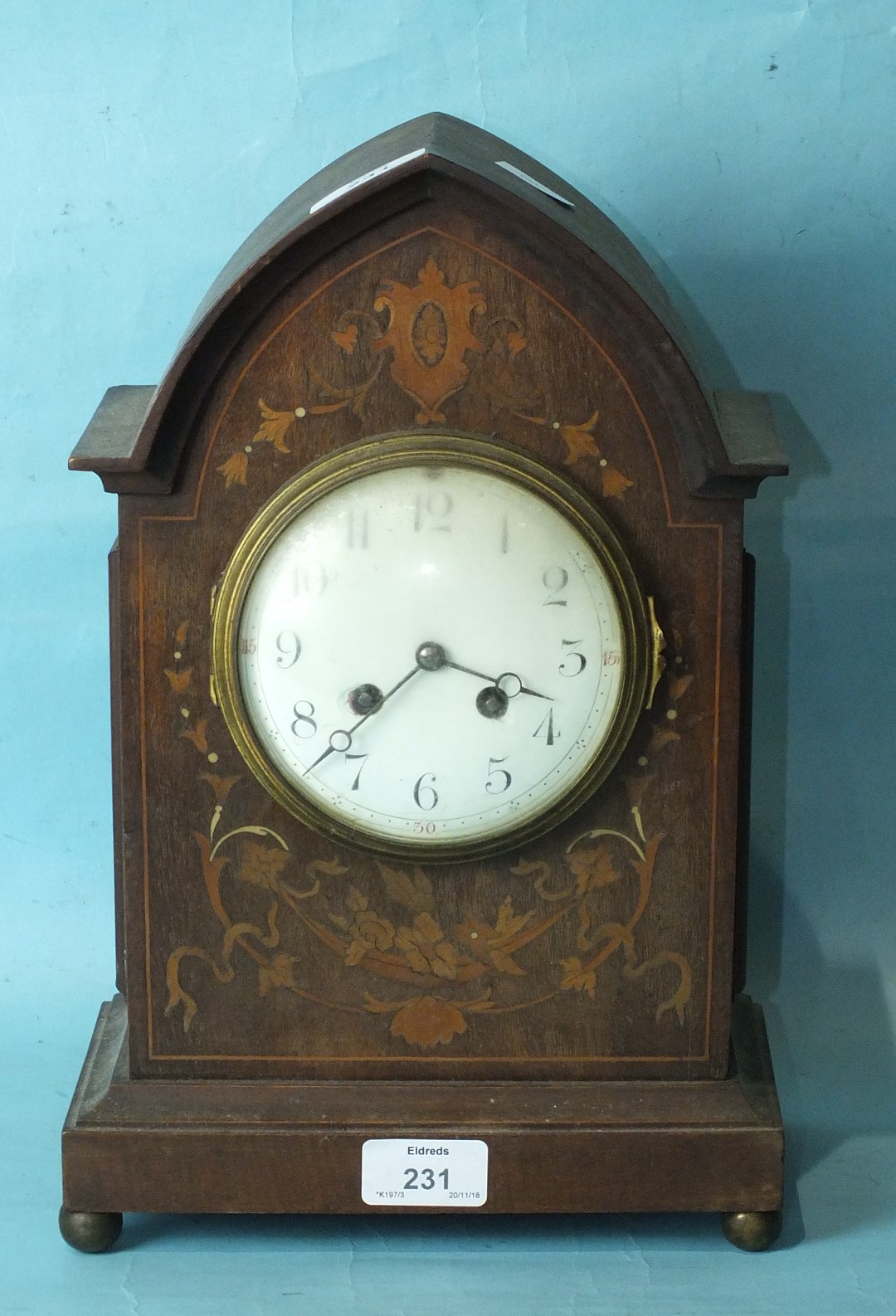 An Edwardian inlaid mahogany mantel clock, the lancet-shaped case inlaid with foliate marquetry,