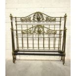 A Victorian 4' 6'' brass bedstead decorated with cast brass foliage centred by a putto.