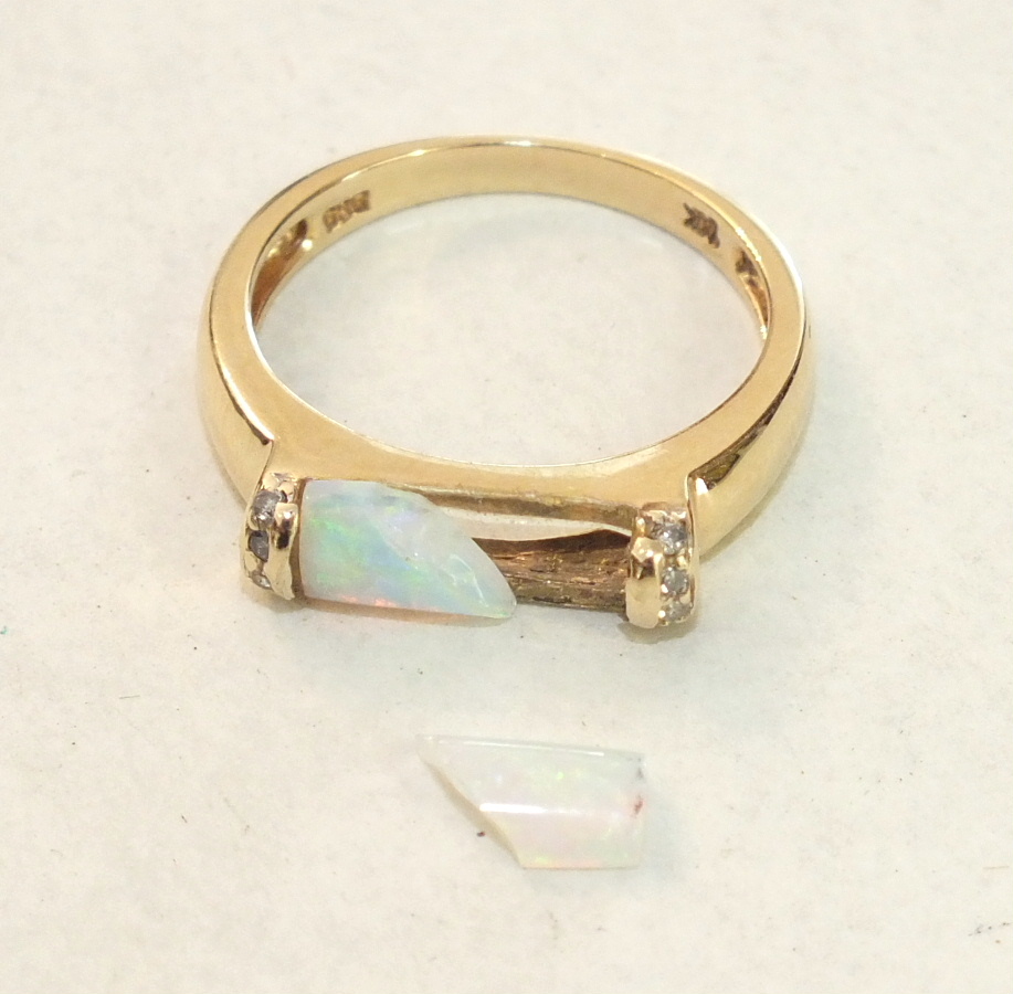 A modern 14ct yellow gold ring set opal baton, (a/f, in two pieces), between diamond-set