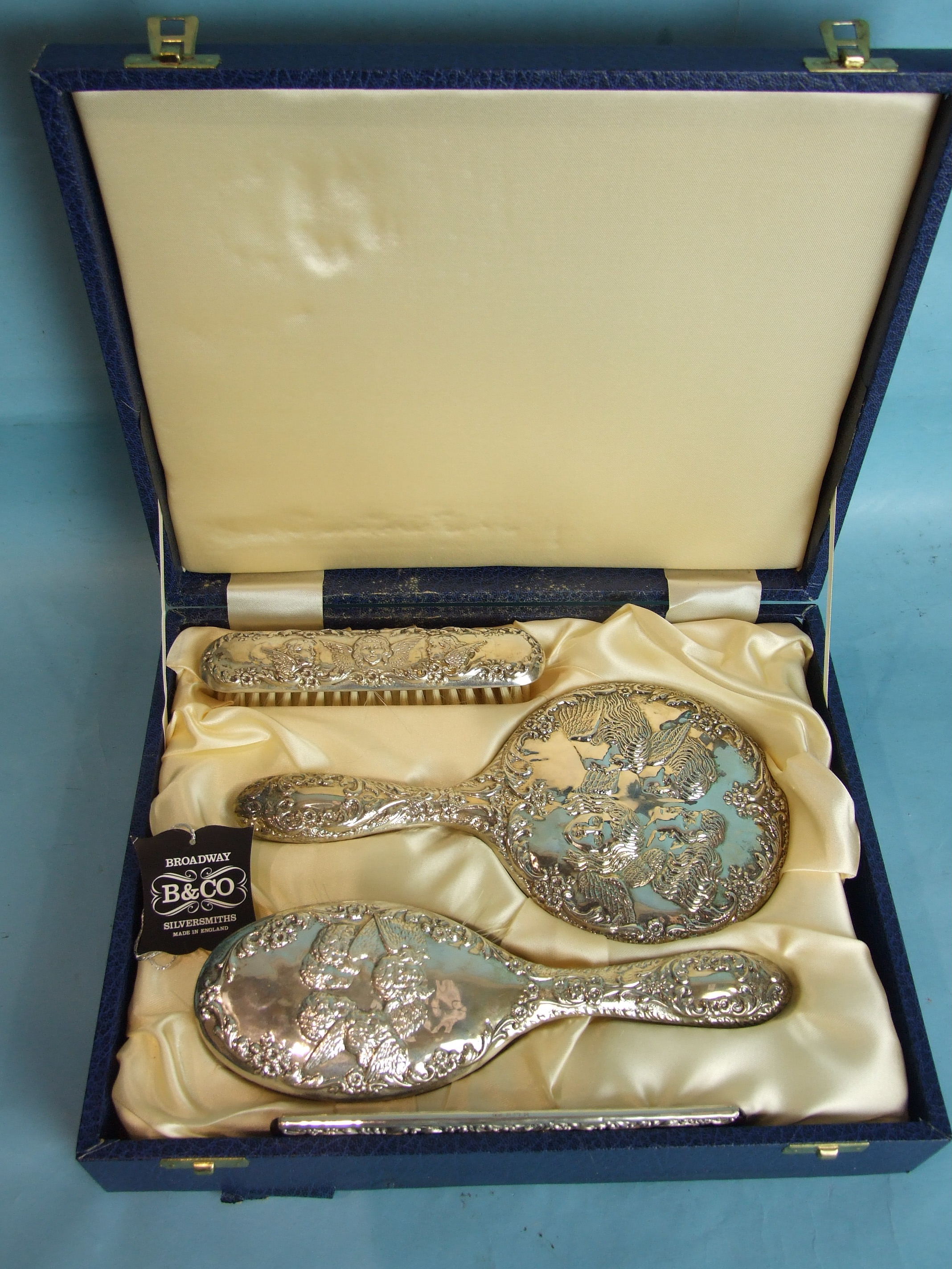 A reproduction silver dressing table set embossed with winged cherubs, in fitted case. - Image 2 of 2