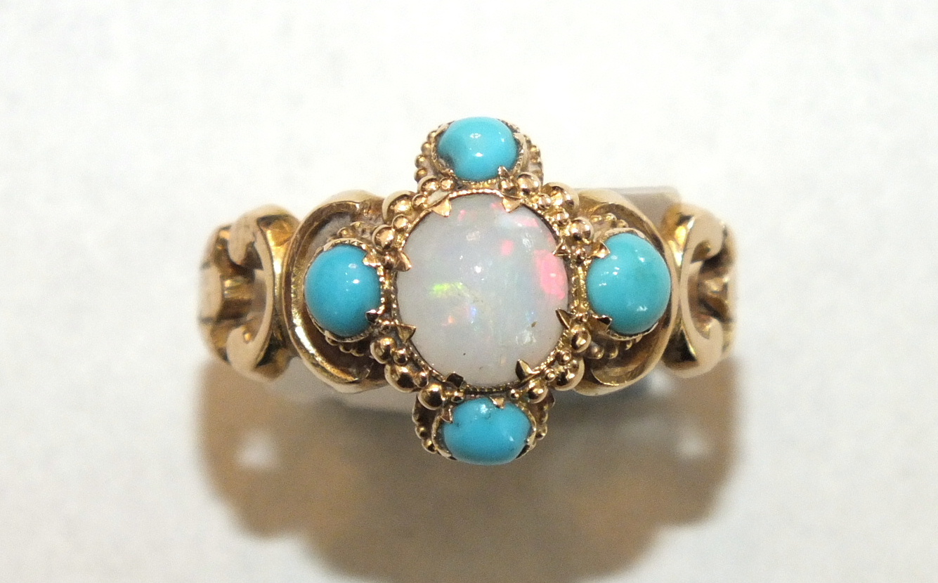 A 19th century ring set opal and turquoise cluster between scrolling shoulders, with engraved shank,