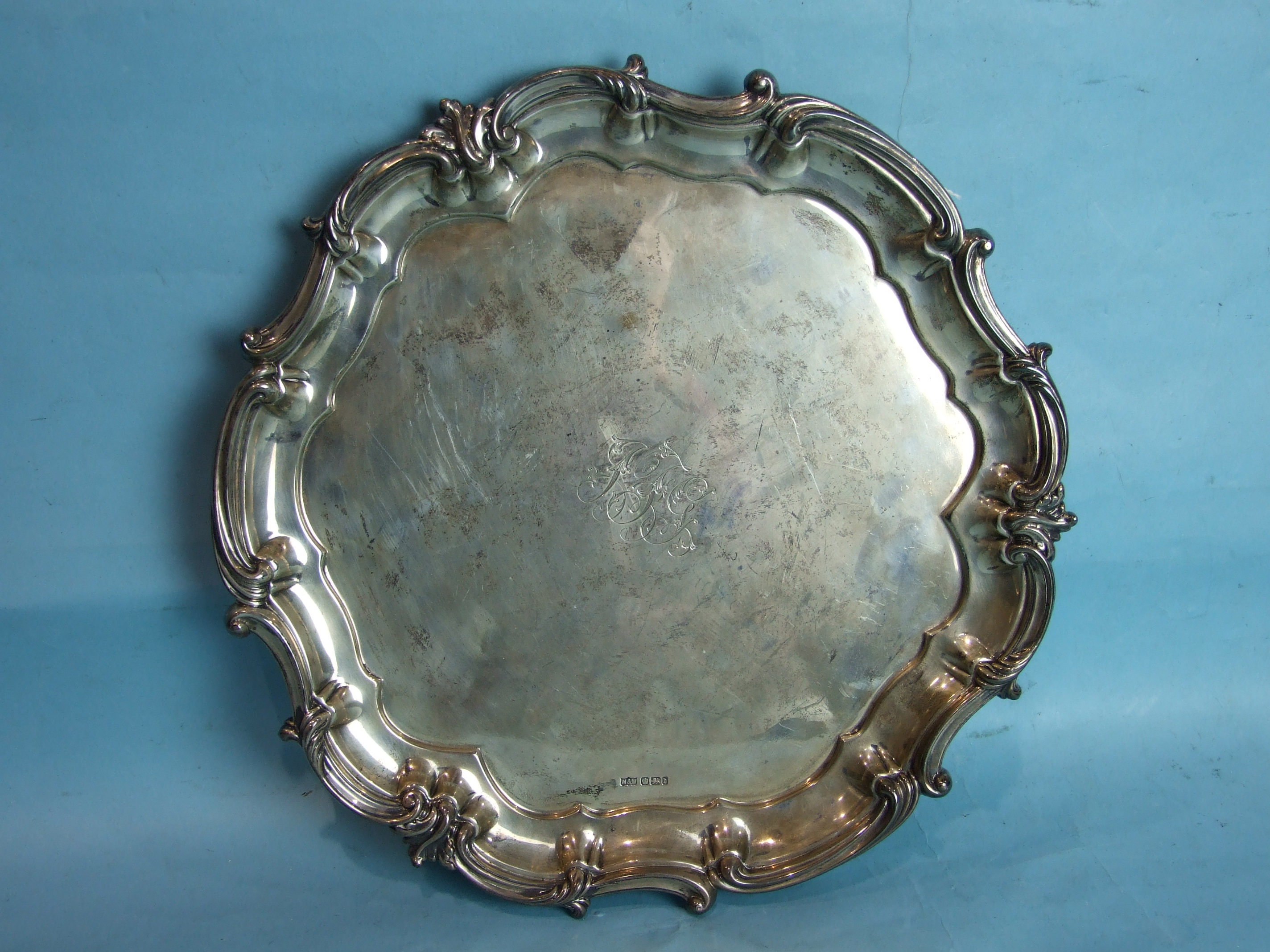 A circular salver with scroll border, on foliate scroll feet, by Mappin & Webb, 34cm diameter, - Image 2 of 2