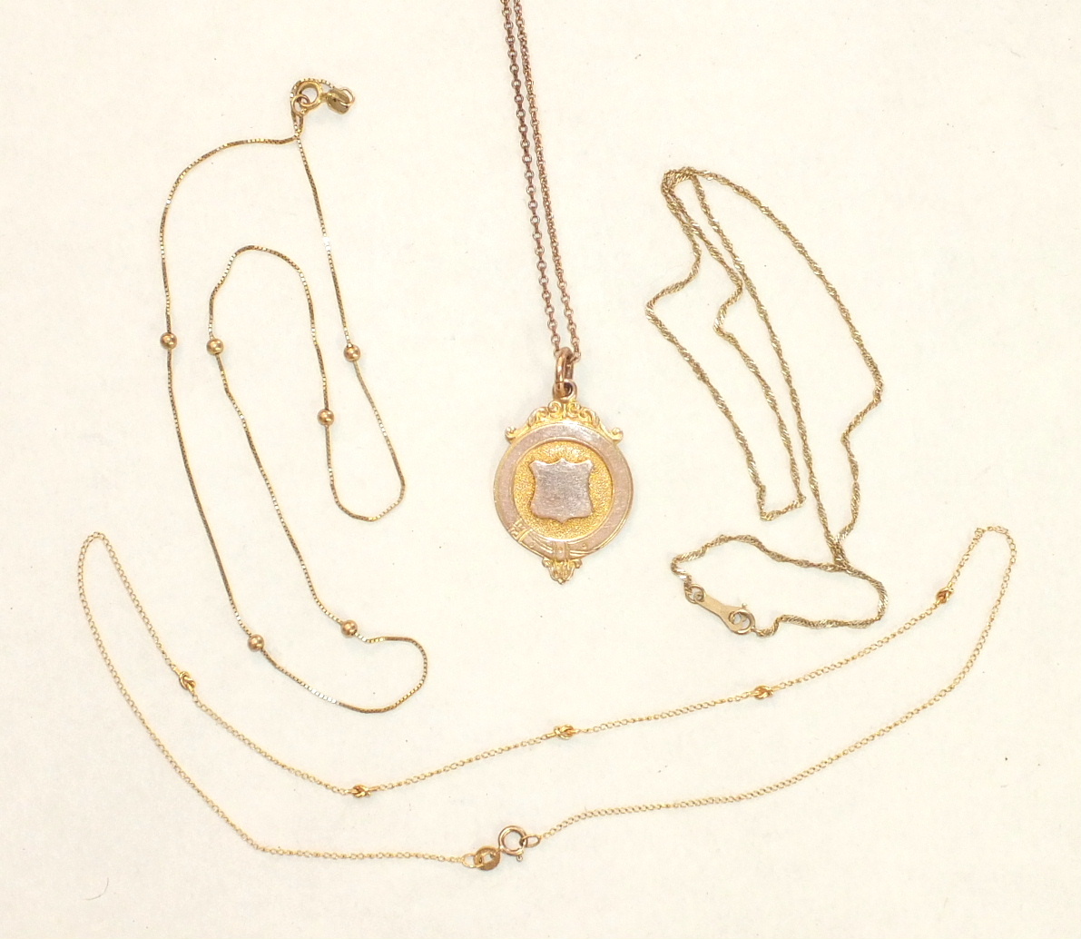 A 9ct gold medallion on chain and three other 9ct gold neck chains, 12.1g, (4).