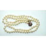 A long string of 95 uniform cultured pearls, 7mm diameter, with 9ct gold clasp set amethyst and seed