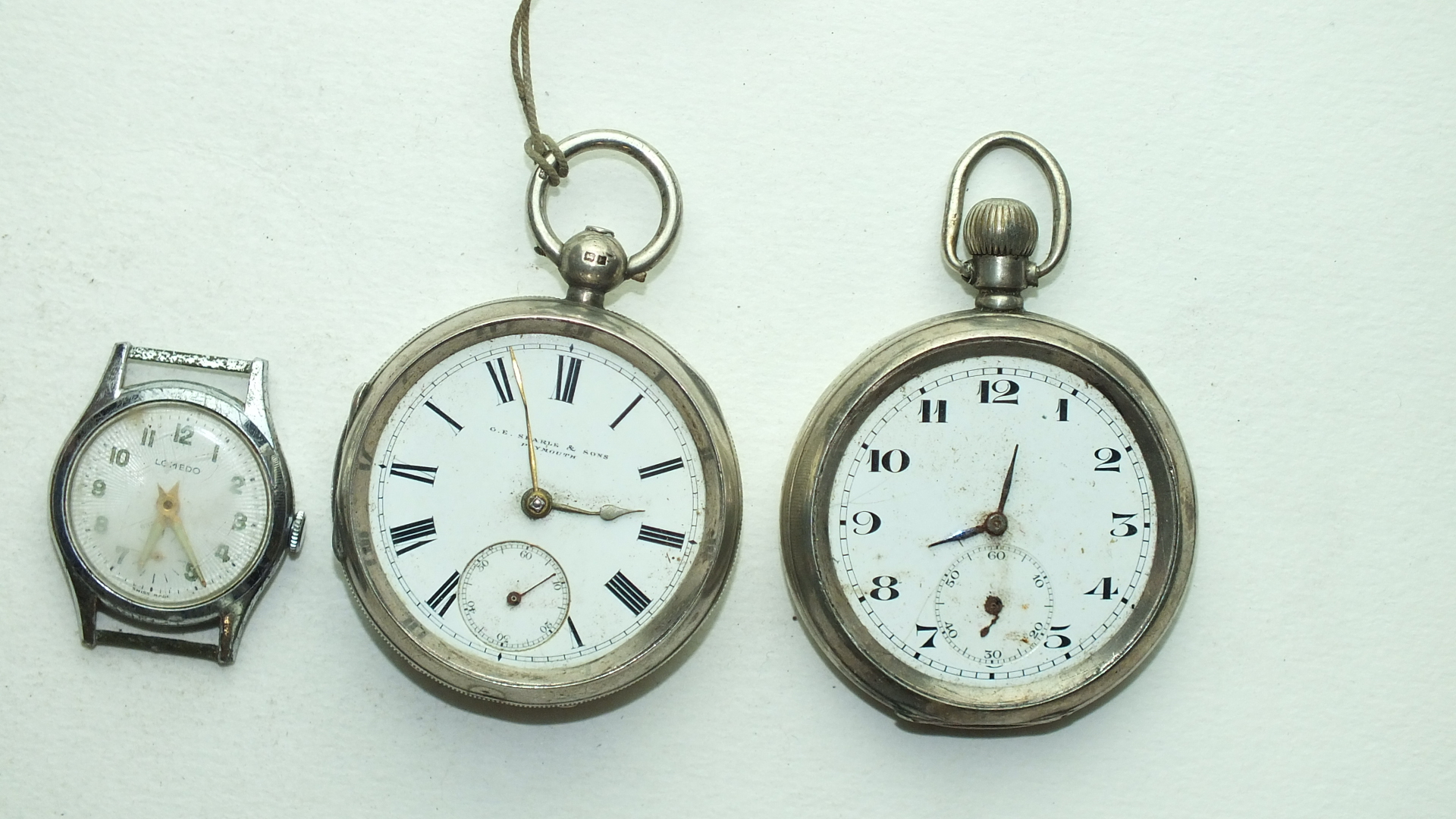 Two silver-cased open-face pocket watches, (1 a/f) and a Lomedo wrist watch, (a/f), (3).