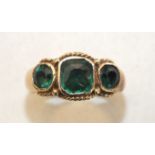 An early-19th century three-stone foiled paste ring, the green pastes collet-set between rope-