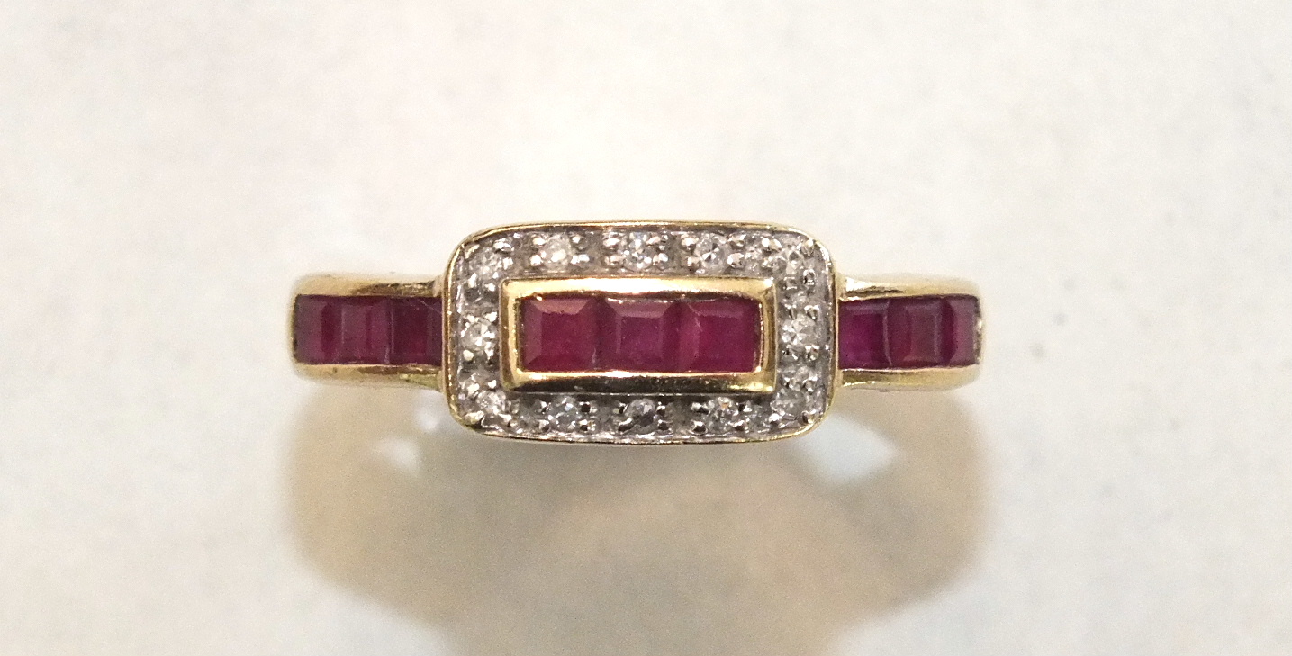 A ruby and diamond ring channel-set a line of square ruby baguettes, with 8/8-cut diamond-set '