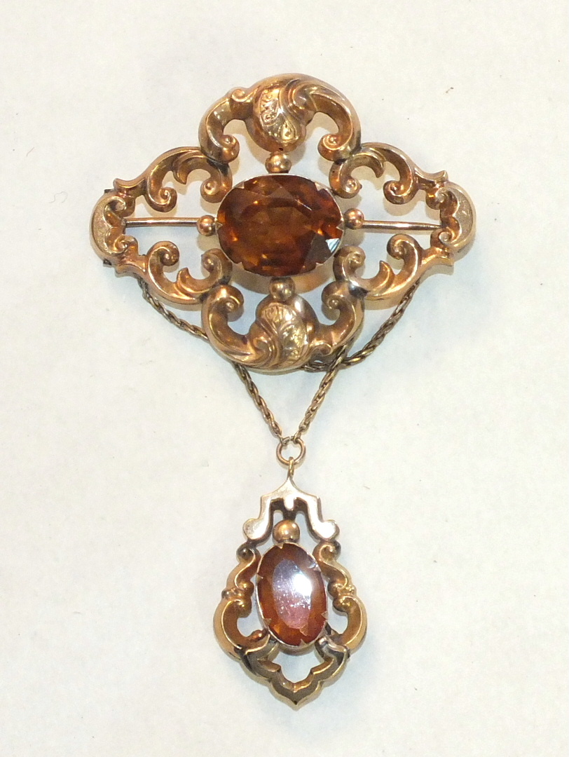 A Victorian brooch of scrolling form set oval citrine, with similarly-set drop below and later