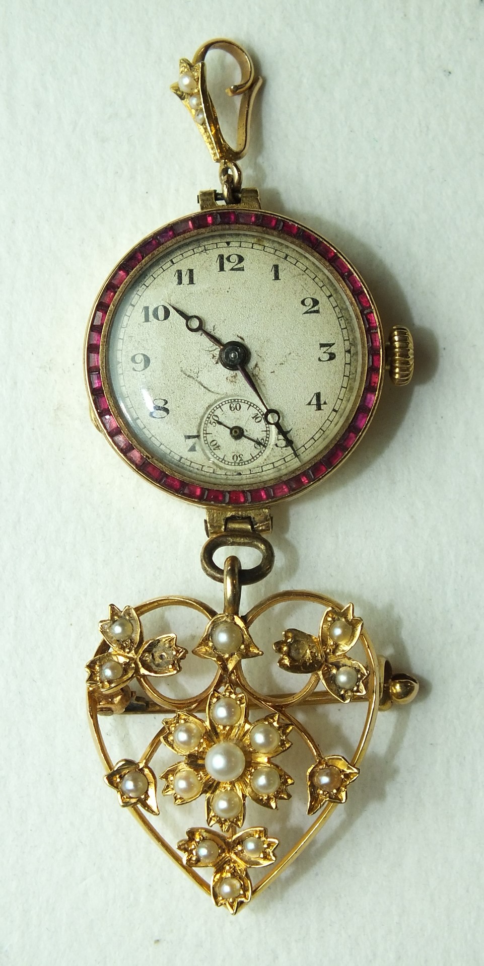 An 18ct-gold-cased wrist watch, (not working), with ruby-set bezel mounted as a fob watch, with a