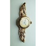A ladies 9ct-gold-cased wrist watch, the circular gold dial with Arabic numerals, on 9ct gold sprung